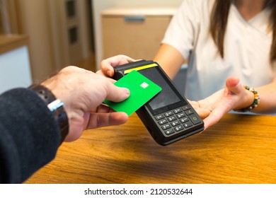 Man paying with credit card via payment terminal in clinic