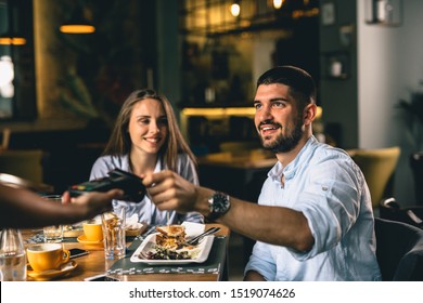 Man Paying For Lunch In Restaurant With Debit Card