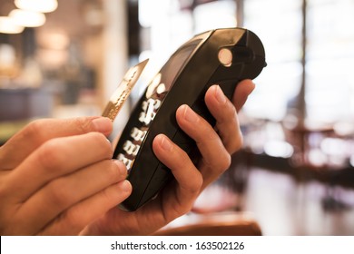 Man Paying With NFC Technology On Credit Card, In Restaurant, Bar, Cafe