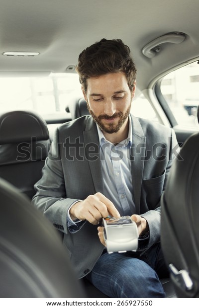 Man\
paying the taxi with the credit card. Typing\
code