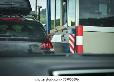 A man pays money to a cashier for a toll road Toll gate motorway entrance