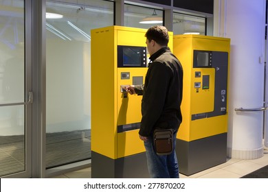 man pays parking in parking machine in the mall
