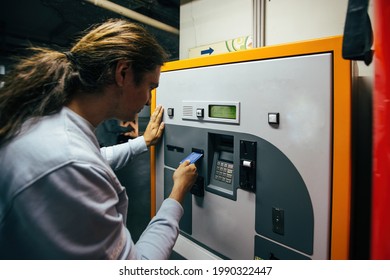 Man pays for underground parking using payment terminal.