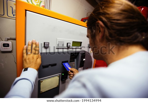 Man\
pays for underground parking using payment\
terminal