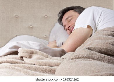 man peacefully sleeping in a quiet bedroom 
