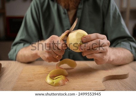 man peeling skin of apple using knife. Healthy eating and cooking concept. Close-up