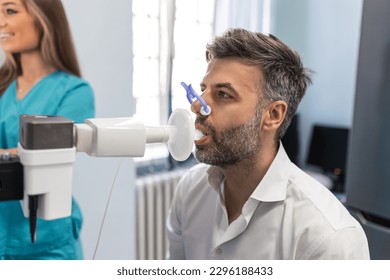 Man performing pulmonary function test and spirometry using spirometer at medical clinic. Spirometry of lungs