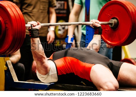 man performs bench press competition powerlifting