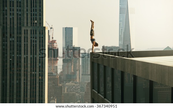 人は高層ビルの縁に立つ の写真素材 今すぐ編集