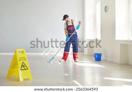 Man performs mopping floor duties as a cleaner, using a mop to clean floors as part of housekeeping service. Cleanup role showcases the essentials of housekeeping and cleaning service work.