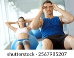 Man, personal trainer and situps with exercise ball for fitness, workout or abdominal training at gym. Male person, athlete or coach with practice for physical activity or strong core at health club