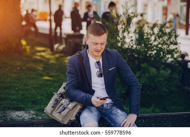 A man with a phone and tablet computer running outdoors on a sunny day