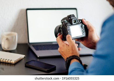 Man with photo camera in hand sitting at desk