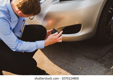 A Man Photographed His Vehicle With Accidental Damage With A Smart Phone.Car Insurance Concept.