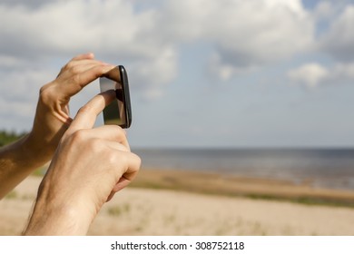 man photographed on the beach using mobile phone - Shutterstock ID 308752118