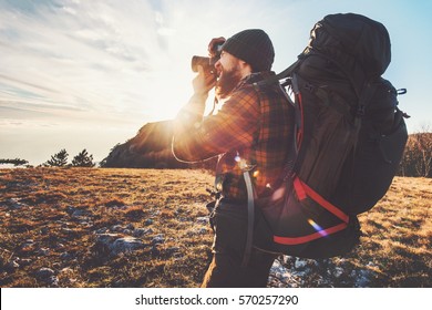 Man photographer with big backpack and camera taking photo of sunset mountains Travel Lifestyle hobby concept adventure active vacations outdoor 
