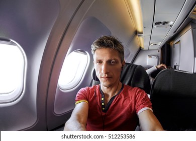 man photographer taking selfie in the airplane - Powered by Shutterstock