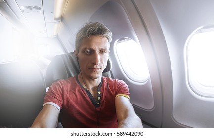 man photographer taking selfie in the airplane - Powered by Shutterstock