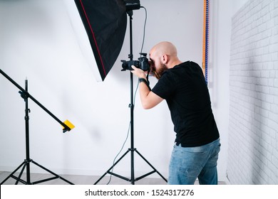 A Man Photographer Works In Studio Taking Photo