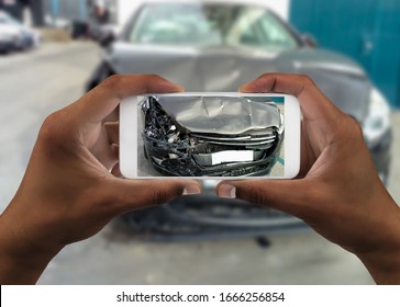 Man Photographing His Car With Damages