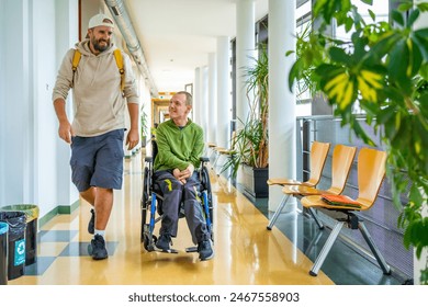 Man with physical disability in wheelchair and friend chatting distracted in the university - Powered by Shutterstock