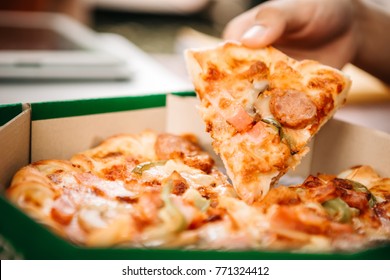 Man Picking Up Hot Pizza Large Cheese Lunch Or Dinner Crust Seafood Meat Topping Sauce With Bell Pepper Or Vegetables By Delicious Tasty, Italian Traditional Fast Food In Paper Board Box.