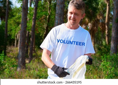 Man Picking Up Litter During A Volunteer Environmental Cleanup Event.