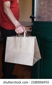 Man Picking Up A Paper Bag At The Door Of His House. Online Shopping. Home Delivery. Vertical Photo.