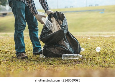 A Man Is Picking Up Trash In A Park, Not Throwing Trash In The Trash Can Ruin The Beauty Of The Garden Area And Also Cause Global Warming And Harm Animals. Concept Of Cleanliness In Public Areas.