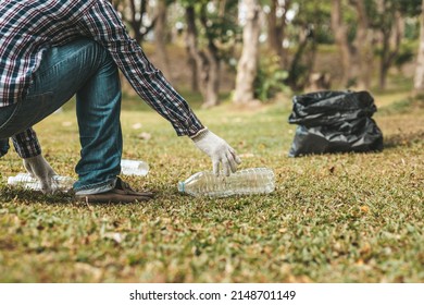 A Man Is Picking Up Trash In A Park, Not Throwing Trash In The Trash Can Ruin The Beauty Of The Garden Area And Also Cause Global Warming And Harm Animals. Concept Of Cleanliness In Public Areas.