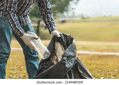 A Man Is Picking Up Trash In A Park, Not Throwing Trash In The Trash Can Ruin The Beauty Of The Garden Area And Also Cause Global Warming And Harm Animals. Concept Of Cleanliness In Public Areas.