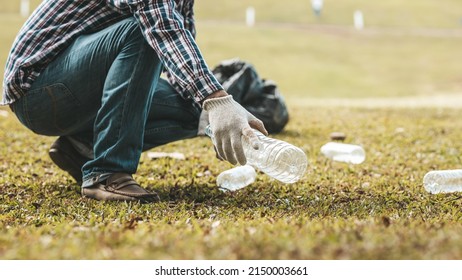 A Man Is Picking Up Trash In A Park, Not Throwing Trash In The Trash Can Ruin The Beauty Of The Garden Area And Also Cause Global Warming And Harm Animals. Concept Of Cleanliness In Public Areas.