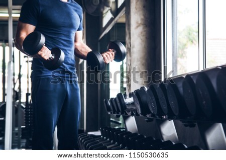 man pickup dumbell in gym . exercise with work out program for healthy 
