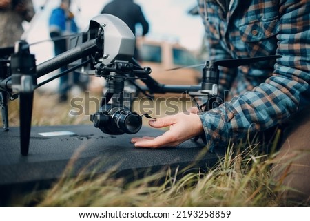 Man pilot checking quadcopter drone camera before aerial flight and filming
