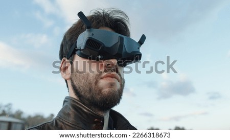 Man pilot a drone with technologic virtual reality glasses and remote controller