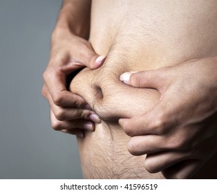 A man pinches his body fat.