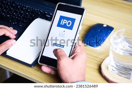 Man placing bid on an IPO (initial public offering) on his phone. Investment concept.