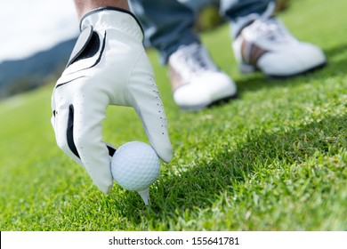 Man Placing Golf Ball At The Tee Box 