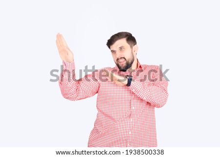 A man in a plaid shirt with a beard raised his hand in front of him as if he wanted to be noticed