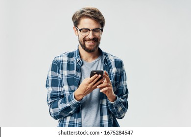 A man in a plaid shirt with a phone in his hands communicating technology - Powered by Shutterstock