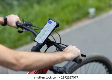 Man planning route using GPS navigation application in mobile phone on his bicycle bike - Shutterstock ID 2192827077