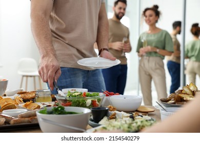 Man With Plate Taking Salad From Buffet Indoors, Closeup. Brunch Table Setting