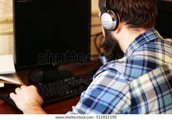 man play computer with\
headphones