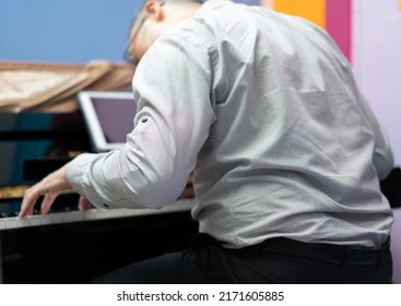 Man Play Piano From Online Learning ,back View