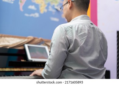 Man Play Piano From Online Learning ,back View