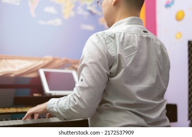 Man Play Piano From Online Learning ,back View