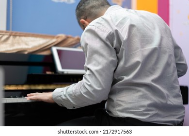 Man Play Piano From Online Learning ,back View