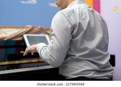 Man Play Piano From Online Learning ,back View