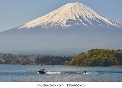 Man Play Wakeboard: an Extreme Water Sport Activity, with Jet Boat in Lake Kawaguchiko with Background of Mount Fuji Covered with Snow in Clear and Sunny day in Spring inJapan - Powered by Shutterstock