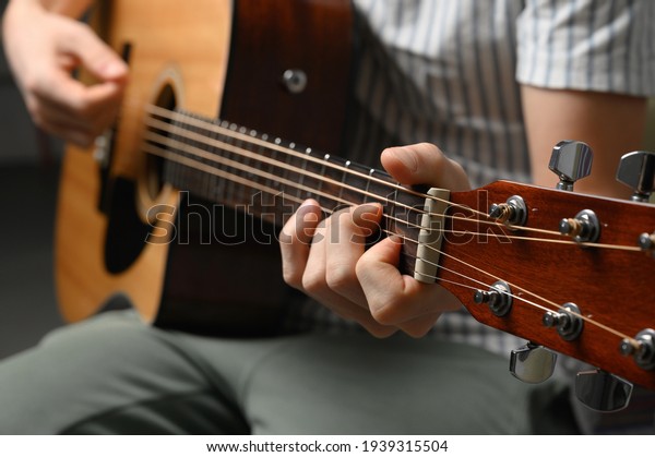 Man playing acoustic guitar, cover for online\
courses, learning at home.